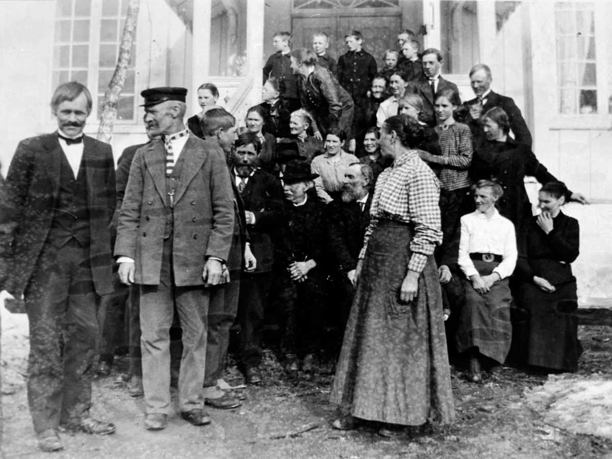 Stor gruppe mennesker samlet i anledning Johan Engebretsen Engeland (1839-1934) sin 80 års-dag. Hovinsholm, Helgøya. Frantz Raknerud, Gustav Antonsen, Laura Bakke, Ivar Hagen, Mads Nordstøen, Magda Raknerud, Johan Engebretsen Engeland, Marte Marie Nordstøen, Peder Magnussen Hagen, Tilla Madsen, Tea, Anna Bakke, Sofie Vestli, Astrid Mortensen Exklo, Alvhild Raknerud, Mathias Moen, Klara Madsen, Frøken Saastad, Otto Hagen, Pauline kokk (eller Ingeborg Hagen), Karl Antonsen, Maurits Martinsen, frøken Røise, Fru Hall.  

Plassering av personer finnes på registreringskjema.