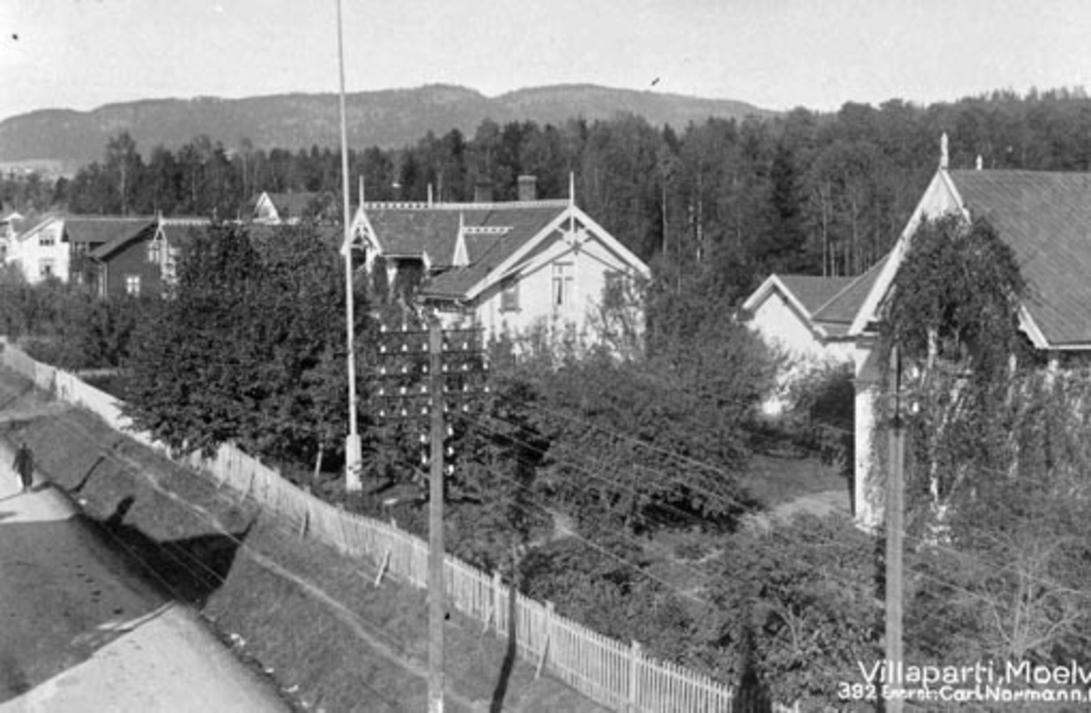 Postkort, Moelv sentrum sett fra Dobloughjørnet, Storgata, gavlen på hotellet til venstre, Fra høyre: Heimdal i Storgata 105, Heimstad i Storgata 103, Sole: Wiensgården i Storgata 101, Alfheim i Storgata 99, Lund (skar) i Storgata 97