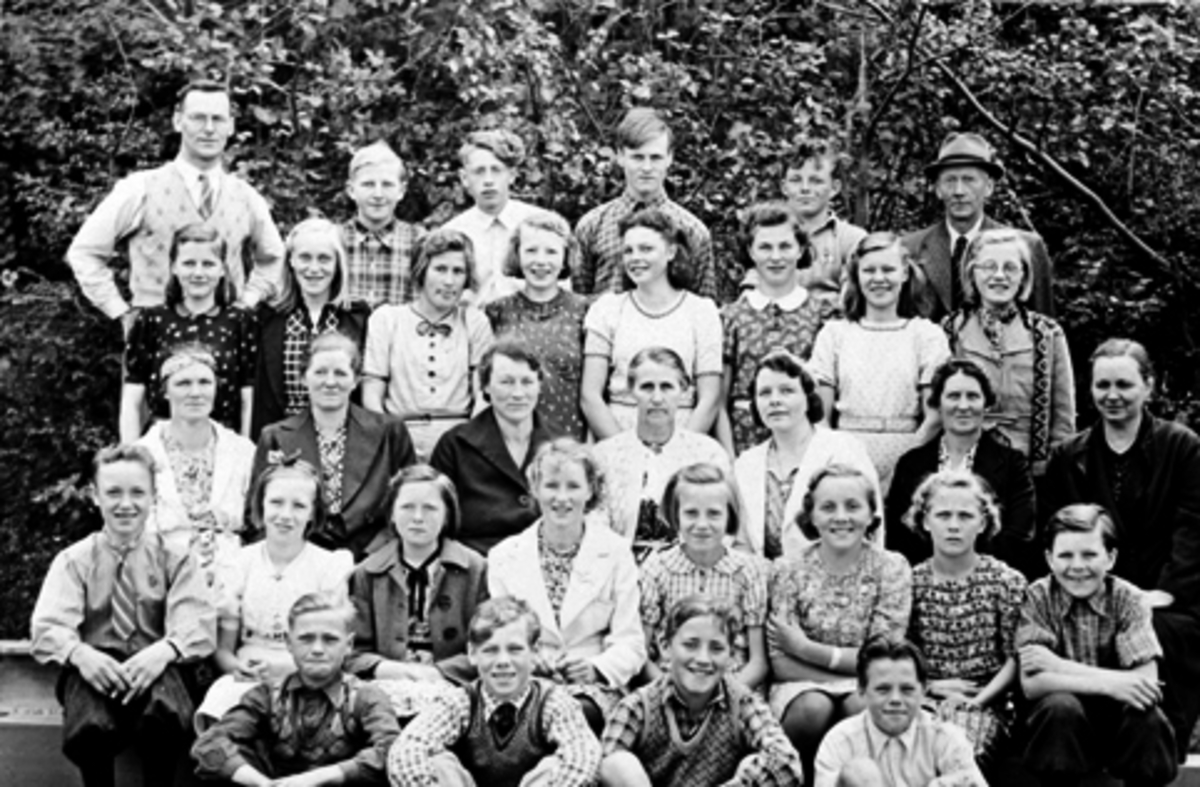 Elever med lærer og noen foreldre på Mauset skole, Brumunddal. Bak fra venstre er lærer C.K. Gundersen, Jens Tørudstad, Kåre Slåttsveen, Erling Engeskaug, Dag Gundersen, Gudbrand Kjernli. Andre rad er Ester Mælum, Magnhild Bekkelien, Synnøve Ellefseter, Oddlaug Tørudstad, Gudmund Dalsveen, Jorun Berger, Olga Fredlund, Louise Granlien. Tredje rad er Helga Sandby, Gunvor Mælum, Elida Engeskaug, Kristine Kjernli, Anfrid Gundersen, Gunda Aaseth, Ellen Aaseth. Fjerde rad er Trygve Myre, Marie Sundmyr, Lilly Mælum, Marie Aaseth, Kirsten Aaseth, Jenny Kjernli, Sylvia Hensbakk. Foran er Odd Flåhagen, Osvald Hovdedalen, Yngvar Morud, Arne Westvang.