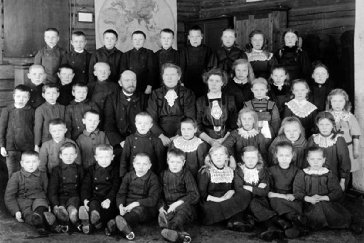 Elever og lærere ved Mauset skole, Brumunddal. Første rekke nummer fire fra venstre er Georg Haugen. Fjerde rekke nummer tre fra venstre er Olav Rønningen. De øvrige er ukjente.