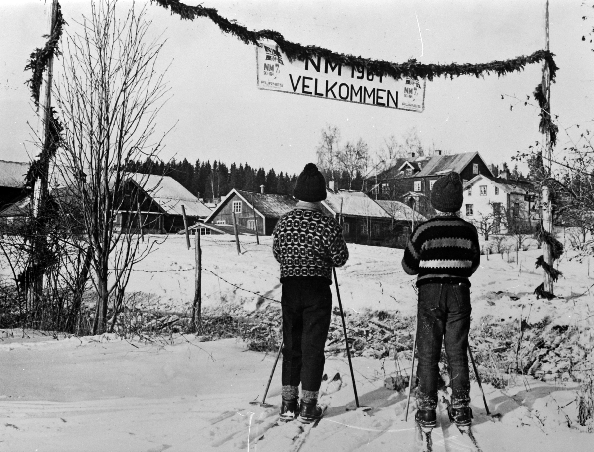 Ringsaker, Furnes, Norgesmesterskap, NM på ski, 21. - 23. 2. 1964, granbarportal med teksten "NM 1964, Velkommen til Furnes", to gutter på ski, gården Alu østre i bakgrunnen,