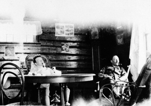 LENSMANN THORVALD HOELSETH OG SØNN RØYKER PIPE, INTERIØR FRA HYTTA PÅ SAVALSETRA