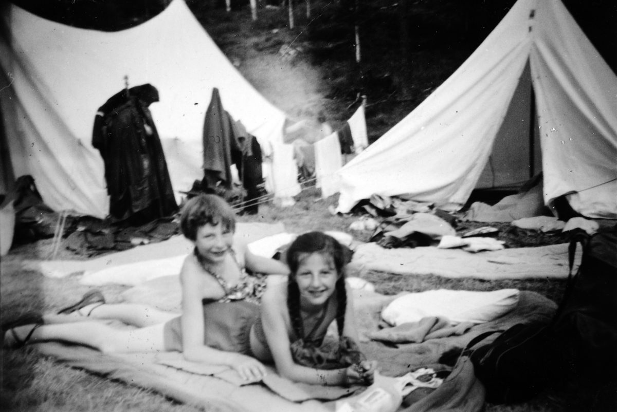 Jentespeidere fra Romedal på speiderleir i Nord-Odal i 1954. Kari Synnøve Sandvold og Ingrid K. M. Johnsen. Klær til tørk utenfor telt. 