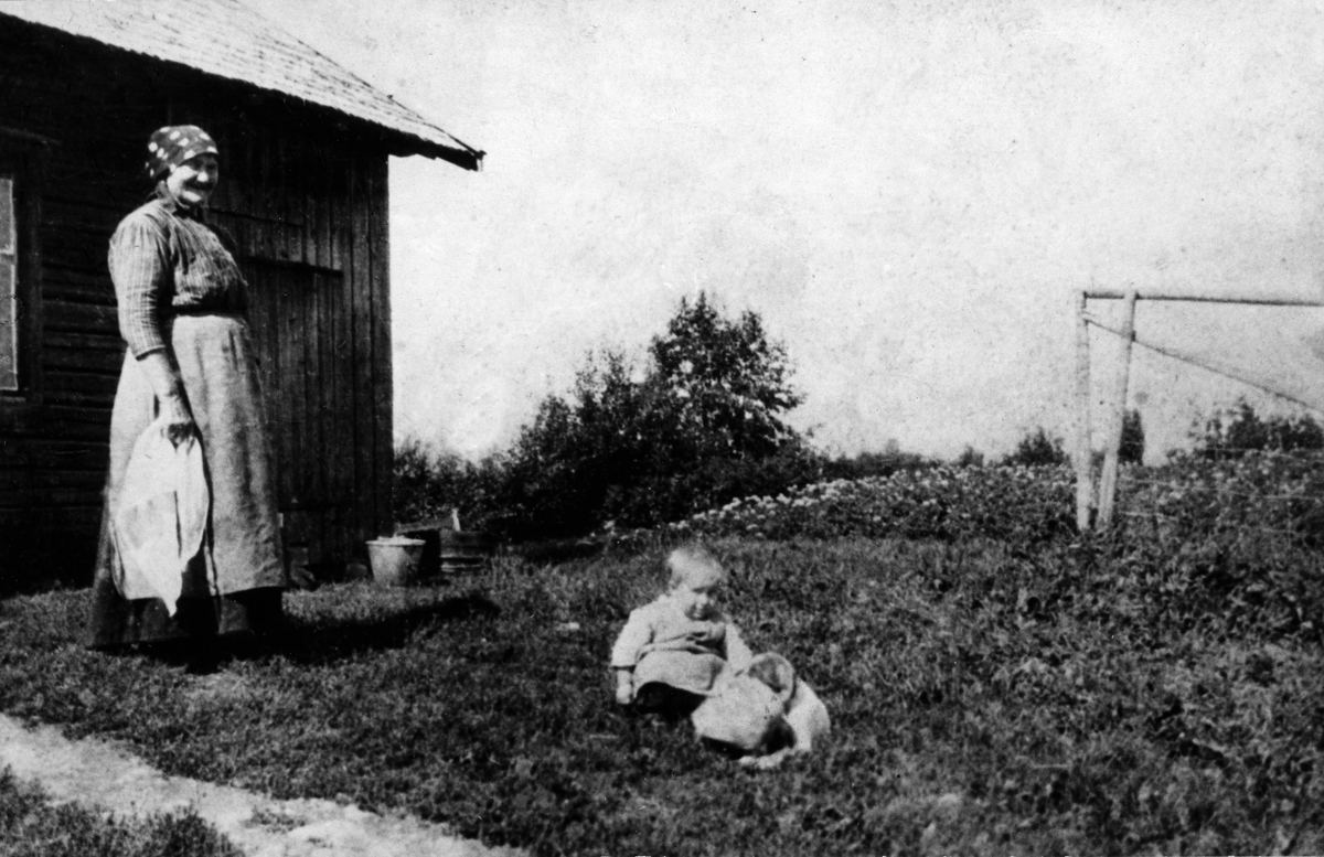 Syverine Holen og barnebarnet Håkon utenfor Nordre Holen ( under Nordvigård) i 1918. Lasskjørere som hentet mjøl på Kvæka eller Kurud mølle stoppet her for å få seg en velfortjent hvil samt kaffe og mat. 