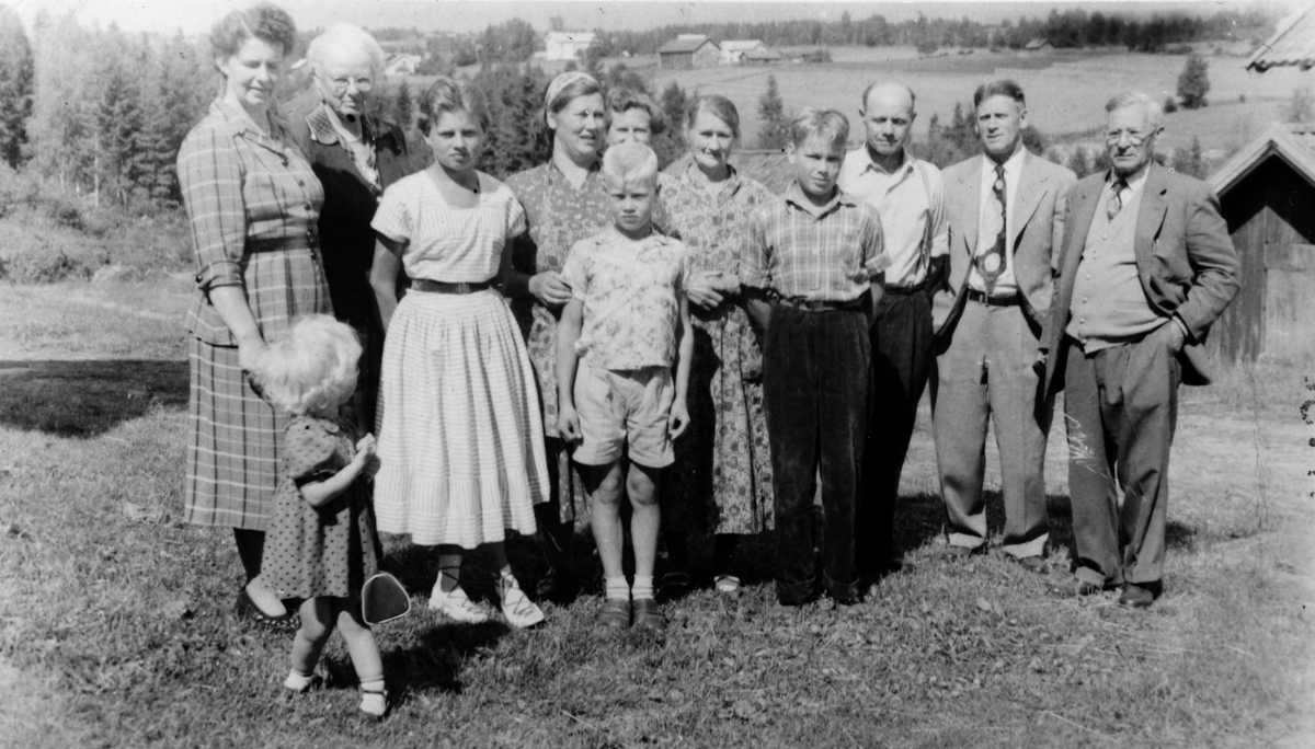 Familiegruppe. Barnet foran er Kari Frydenlund g. Opøyen. F. v. Anna Frydenlund, Marcia Pedersen, Gerd Nilsen, Valborg Nilsen, Viktor Nilsen, Evelyn Cleary, Anne Gudrun Jensen, Terje Nilsen, Alfred Nilsen, Arthur Frydenlund, Anton Pedersen. 
Utvandrere fra Frydenlund/Skjellet til Amerika, New Hampshire, på Norgesbesøk i 1956.