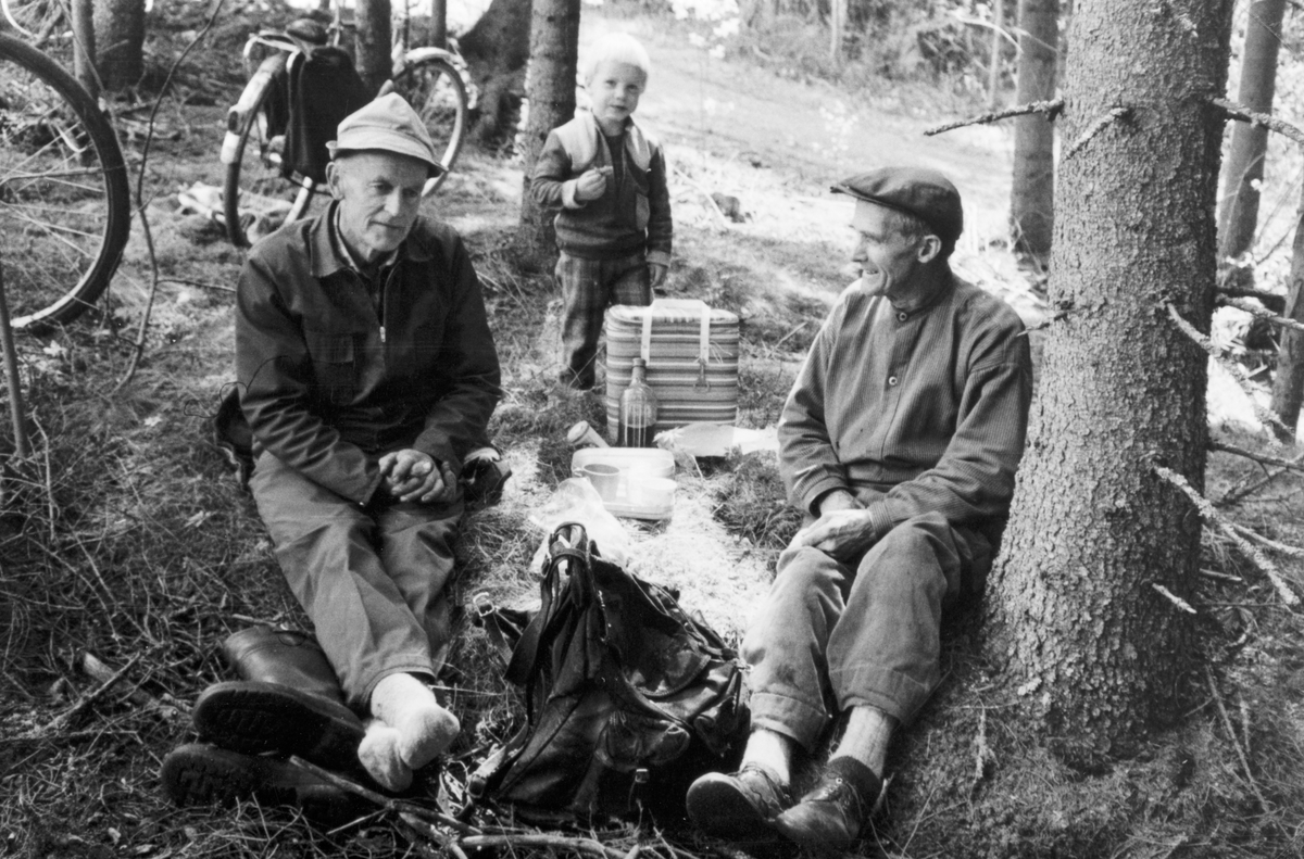 Sæter østre i Vallset, mai-juni 1982. Skogplanting hos Jon Haugen. Rolf Mæhlum og Jon Haugen i kvila. Jon brukte den gamle velbrukte skinnsekken etter sin onkel, Ole Sæter. I tillegg hadde han noe så moderne som en frysebag, der han oppbevarte "hembrygd øl" til lesking av tørre struper. Eskil Rønningsbakken står i bakrunnen. (skrevet av Oddmund Rønningsbakken)