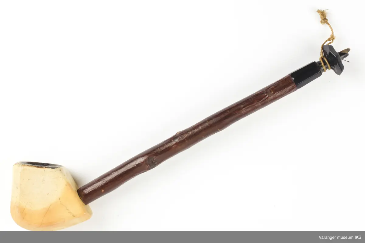 Pipe med hode av merskum. Skaft av bjørkekvist, endestykke og påskrudd krans av ibenholt. Munnstykket avbrukket.