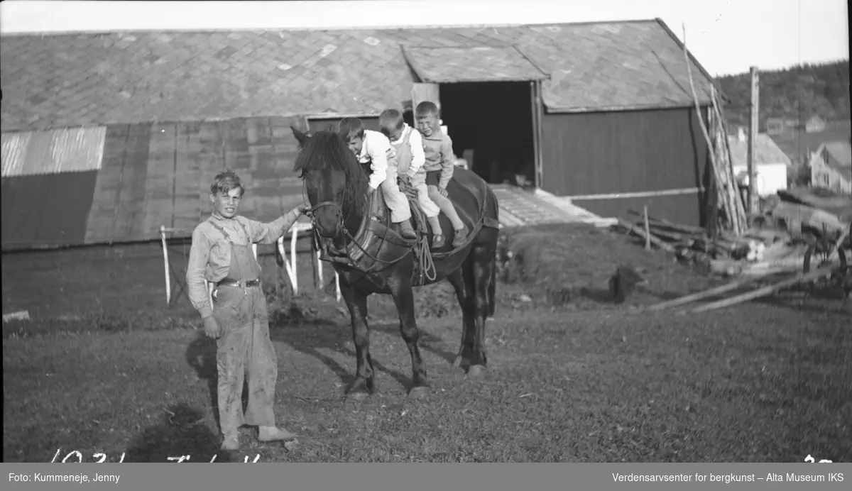 Dagliglivet i Kummenejegården med låve i bakgrunn. 1931.
4 barn med hest.