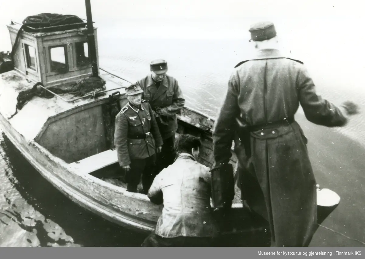 Tyske offiserer i en båt. En ukjent sivil holder båten. Gamvik 1941/42