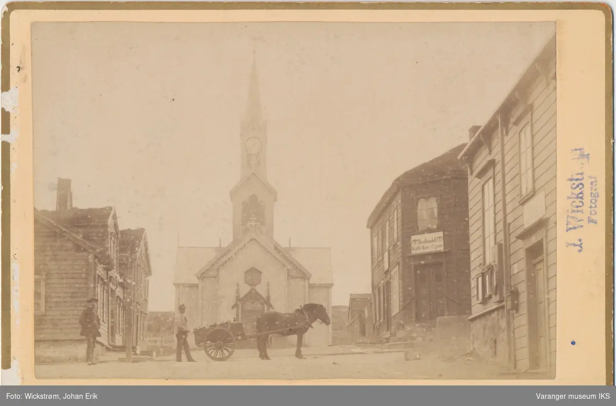 Vardø kirke sett fra kirkebakken, to menn med hest og vogn foran