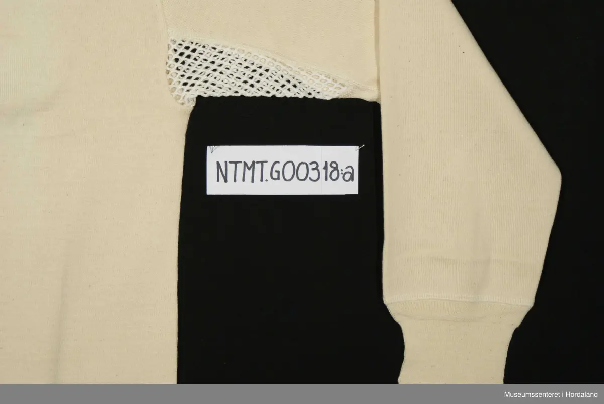 Lange ermer med brotavslutning, rund hals, skulderstykke, kile med helsetrøyestoff under ermer.