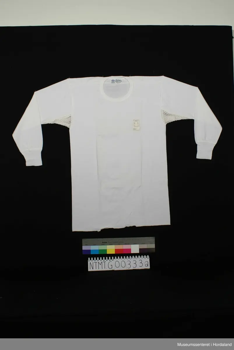 Lange ermer med brotavslutning, rund hals, skulderstykker, kile under ermer.