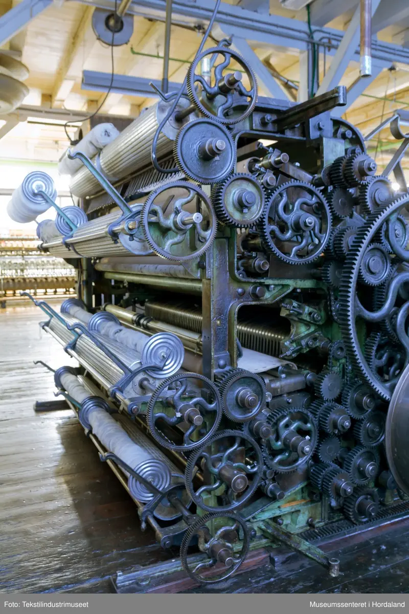 Kardeverk med tre kardemaskiner som er kopla saman og arbeider i serie, frå Oscar Schimmel & Co i Chemnitz, Tyskland. Frå ullinntaket i eine enden av maskina, blir ulla ført over valsar med metallkardar på, som fjernar ureinheiter og løyser opp floker i ullfibra. Ulla blir karda ein gong før den går over eit transportband i tre, blir snudd og karda to gonger til før det karda ullfloret går gjennom ein flordelar som deler det opp i remser. Remsene blir rulla opp på store metallspolar, og blir då kalla forgarn. I forgarnet ligg alle ullfibra etter kvarandre, men garnet er utan styrke og må spinnast for å bli til brukbart garn. 

Maskina var i bruk på Salhus Tricotagefabrik (1859-1989), og hadde her internt maskinnummer 5. Kardeverket står i hesteskoform med ullinntaket og ei kardemaskin på ei sida, to kardemaskiner og flordelaren på andre sida, og eit transportband i tre som bindeledd mellom dei to. Kardeverket blir drive av tre elektriske motorar som er festa til golvet på innsida av 'hesteskoen'. Maskina er grønmåla, med mange dekorative tannhjul med bua eiker, typisk for maskiner frå rundt 1900.

Det har seinare blitt montert ein støvsugar på kardeverket, som syg opp støv ved flordelaren, og transporterer det tilbake til ullinntaket. Røyra til støvsugaren ser 'heimelaga' ut, og er sett saman med bl.a. teip og ulike typar røyr.