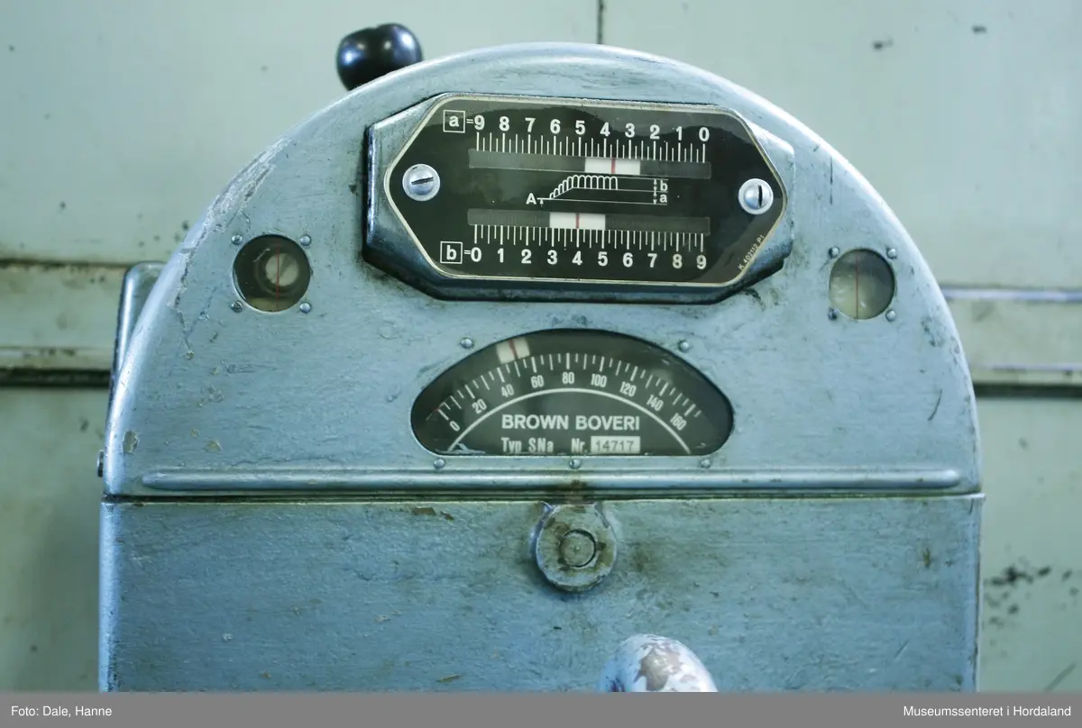 Elektrisk ringspinnemaskin (1958) frå det sveitsiske selskapet Rieter. Øvst på maskina plasserer ein spolane med forgarn frå kardemaskina. Reint teknisk er det tre hovudelement i spinninga:  forgarnet blir strukke, tvista (snodd) for å få meir styrke, før det ferdige garnet blir oppvikla på ein spole eller 'spinnepipe'. Tråden går under eit transporthjul i tre, gjennom støypte løpegangar og vidare nedover: Garnet blir snodd ved at garnet passerer ein løpar som beveger seg på ein ring, før det blir samla på ein sylindrisk metallspole. Det er ei rekkje små støvsugarar langs heile maskina, små røyr som stikk ut over spolane. Desse syg til seg støv og/eller tråden viss den ryk, for å unngå at den kjem inn i maskina. Trådrestar og støv blir samla opp i eit oppsamlingskammer på venstre sida av maskina. Der er det òg ein målar som måler kor mykje maskina spinner.

Drivverket og ein stjernemotor sit på høgre sida av maskina. På sida står det "Rieter" i raudt, og det er to målarar som måler omdreiingar/hastigheit på maskina. Det er ei rekkje med 136 koner på kvar side. Maskina kan byggjast på i seksjonar, og slik utvidast etter behov, noko som er vanleg for spinne- og spolemaskiner.