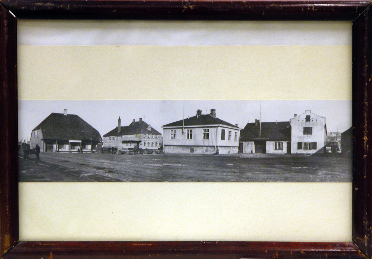 Fotografi av Slaveriet, Tavern, Toldboden og bryggen bak sett fra Olavshall område.
Bilde er satt sammen av tre fotografier. Slaveriet og Tavern på ett, Toldboden på det andre og bryggen bak på det tredje, for så å sette dem sammen til et vidvinkel motiv.