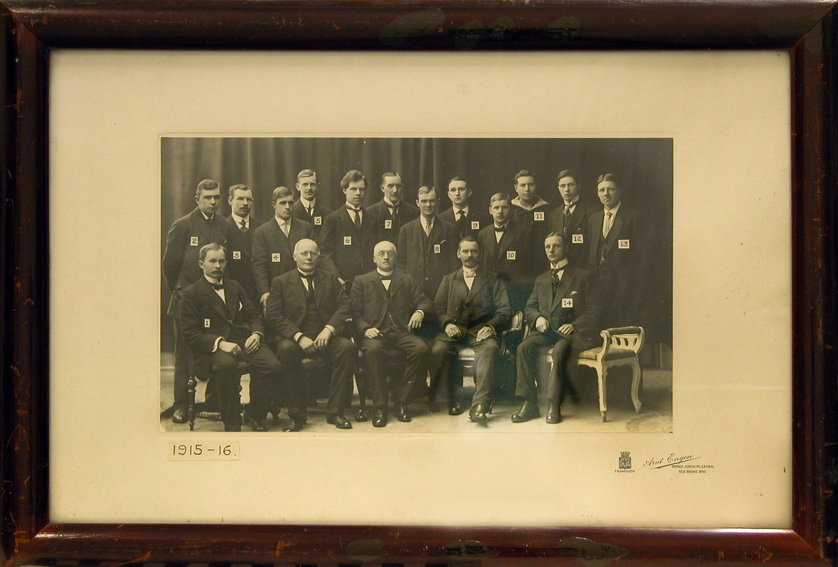 Gruppebilde, innendørs, av elever og lærere i skipsførerklassen av 1915-1916. Antagelig ved Trondhjems Sjømandsskole. 