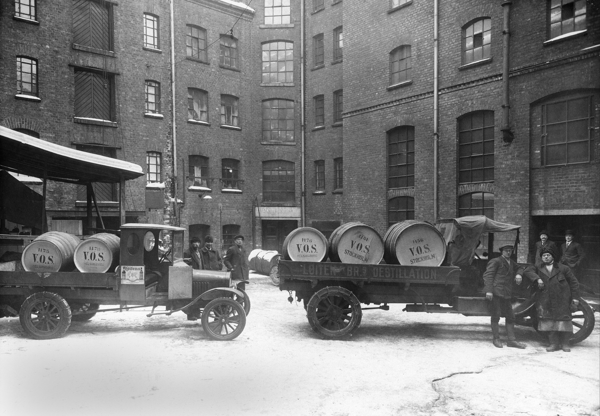 Løiten Brænderi avdeling Christiania, Løiten Brænderies Destillation, Karl den XIIs gate 7, Lastebiler et tonns Ford TT til venstre produksjonen av den startet ikke før i 1917. Ukjent
lastebil til høyre, kjører brennevinsfat, sjåfører,