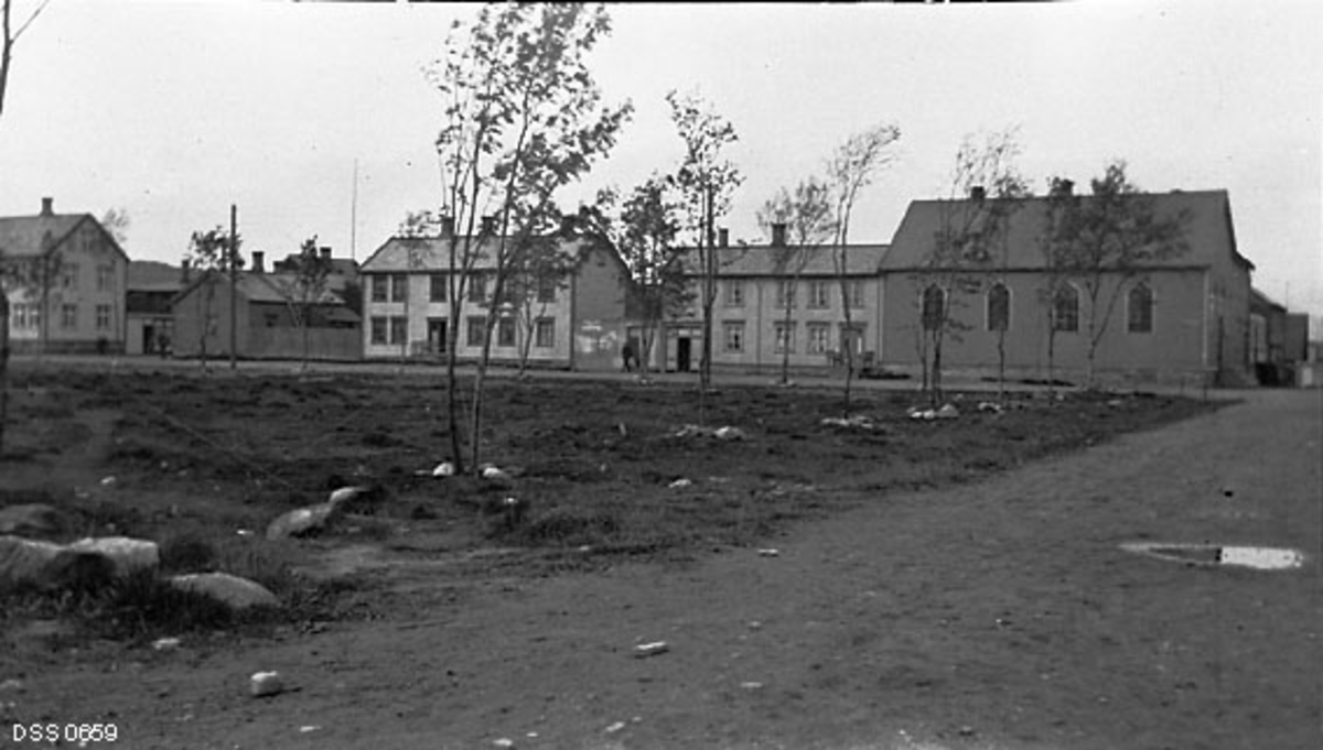 Byparken i Bodø, slik den så ut i 1912.  Vi ser Biskop Kroghs gate i forgrunnen.  Den krysses av Dronningens gate ved bygningsrekka i bakgrunnen.  Huset på hjørnet mellom de to gatene (til høyre i dette bildet) var Frelsesarmeens forsamlingslokale.