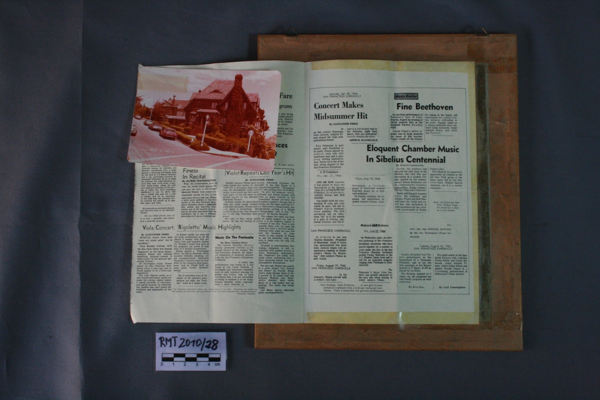 Mannsperson, sittende, med bratsj i hånden.