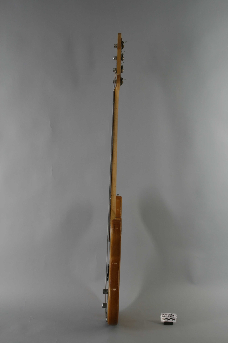 Korpus i lyst lakkert tre. Rødt plekterbrett. 20 tverrbånd på halsen. Volum- og bass/diskant (tone)- kontrollknapper. Split single-coil pickup. Skrue for reim på venstre sarg.