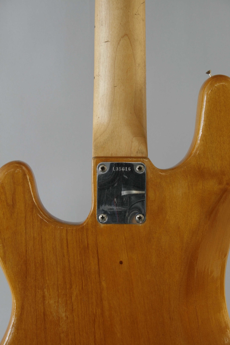 Korpus i lyst lakkert tre. Rødt plekterbrett. 20 tverrbånd på halsen. Volum- og bass/diskant (tone)- kontrollknapper. Split single-coil pickup. Skrue for reim på venstre sarg.
