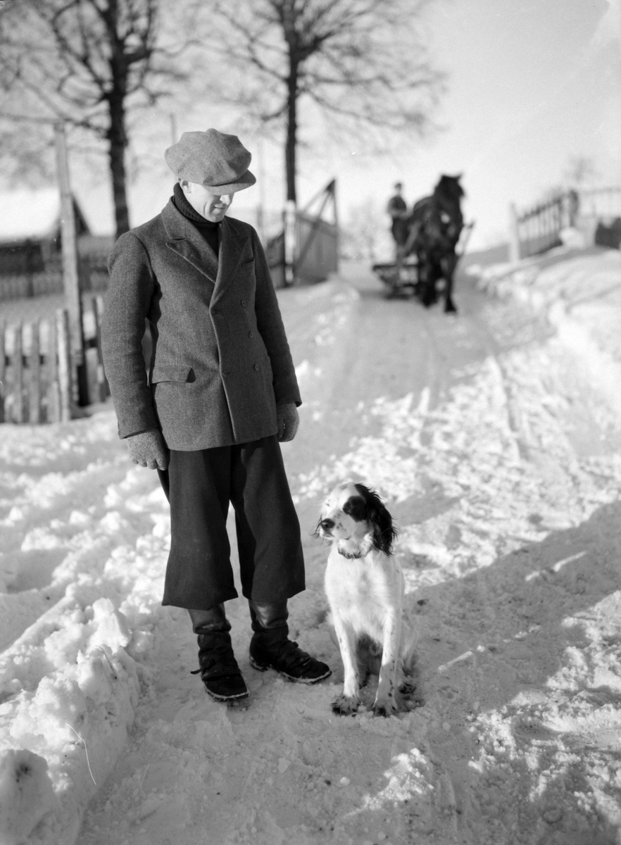 Ringsaker, Helgøya, Hovinsholm, Mann med hund, foto fra branntomta etter hovedbygningen som brant ned til grunnen den 20. desember 1937.
