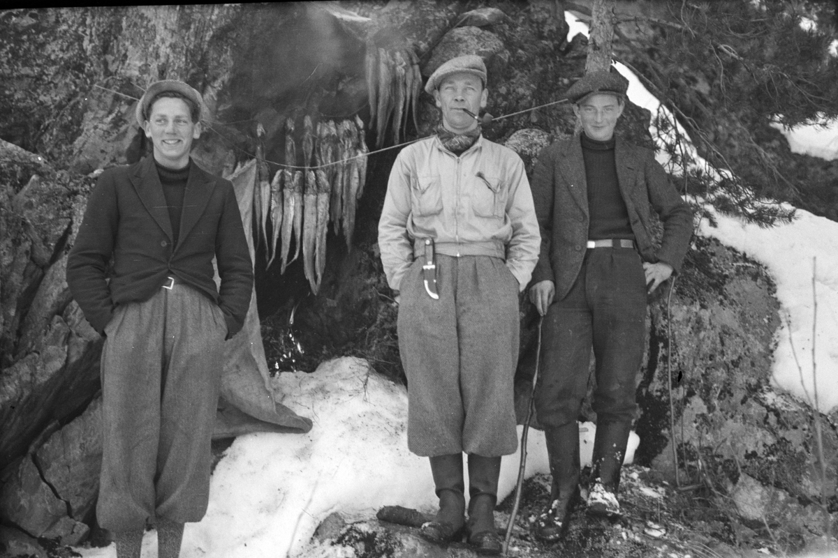 Gruppe 3 ukjente fiskere med fiskefangst. Røyking av fisk, ukjent sted. 
