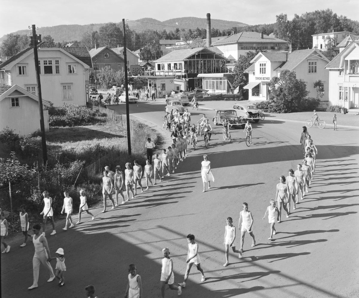 Turnstevne i Moelv i 1959. Turnerer marsjerer gjennom Storgata på veg til Idrettsparken. 