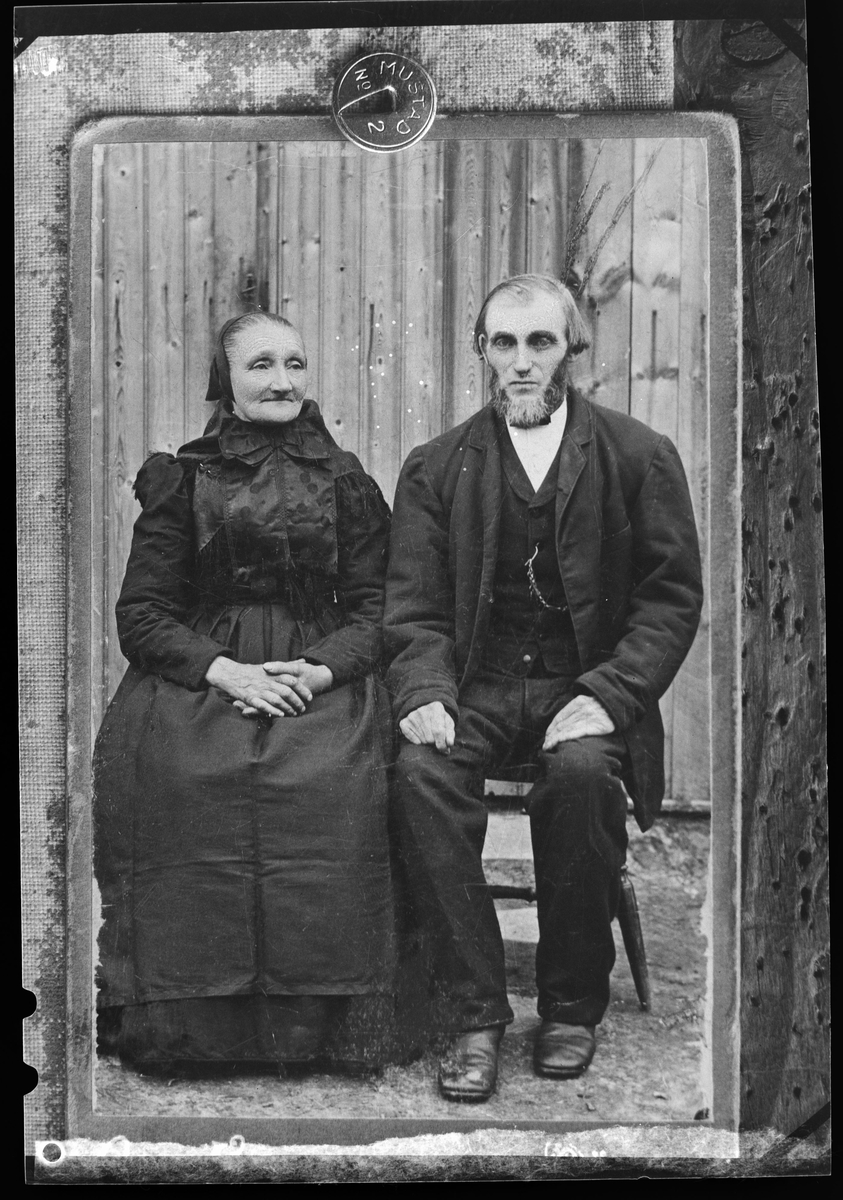 Portrett av eldre par, hun i tradisjonelle rørosklær. Reproduksjon
