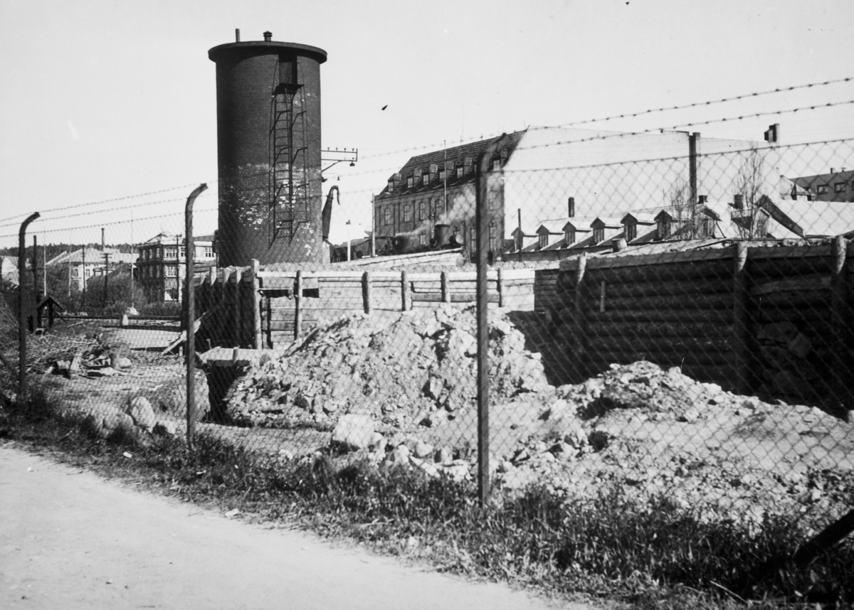 2. verdenskrig. Tysk bunkers og skyttergraver, vaktpost ved vanntårnet på Hamar jernbanestasjon, mai 1945.