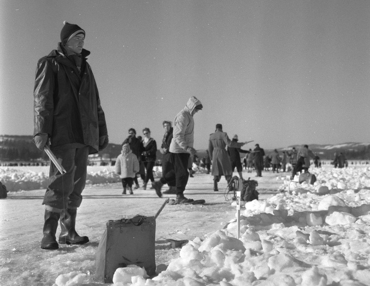 Pilkekonkurranse utenfor Strandsaga i Brumunddal 09. 03. 1958. 
Fiskekonkurranse på Mjøsisen. Isfiske. ukjent pilker. 
Premier i pilkekonkurransen var bla. en bil, Skoda 1958 modell, motorsykkel, kjøleskap, reiseradio. Se. Na-00293-31 og Na-00293-32 for flere opplysninger. 