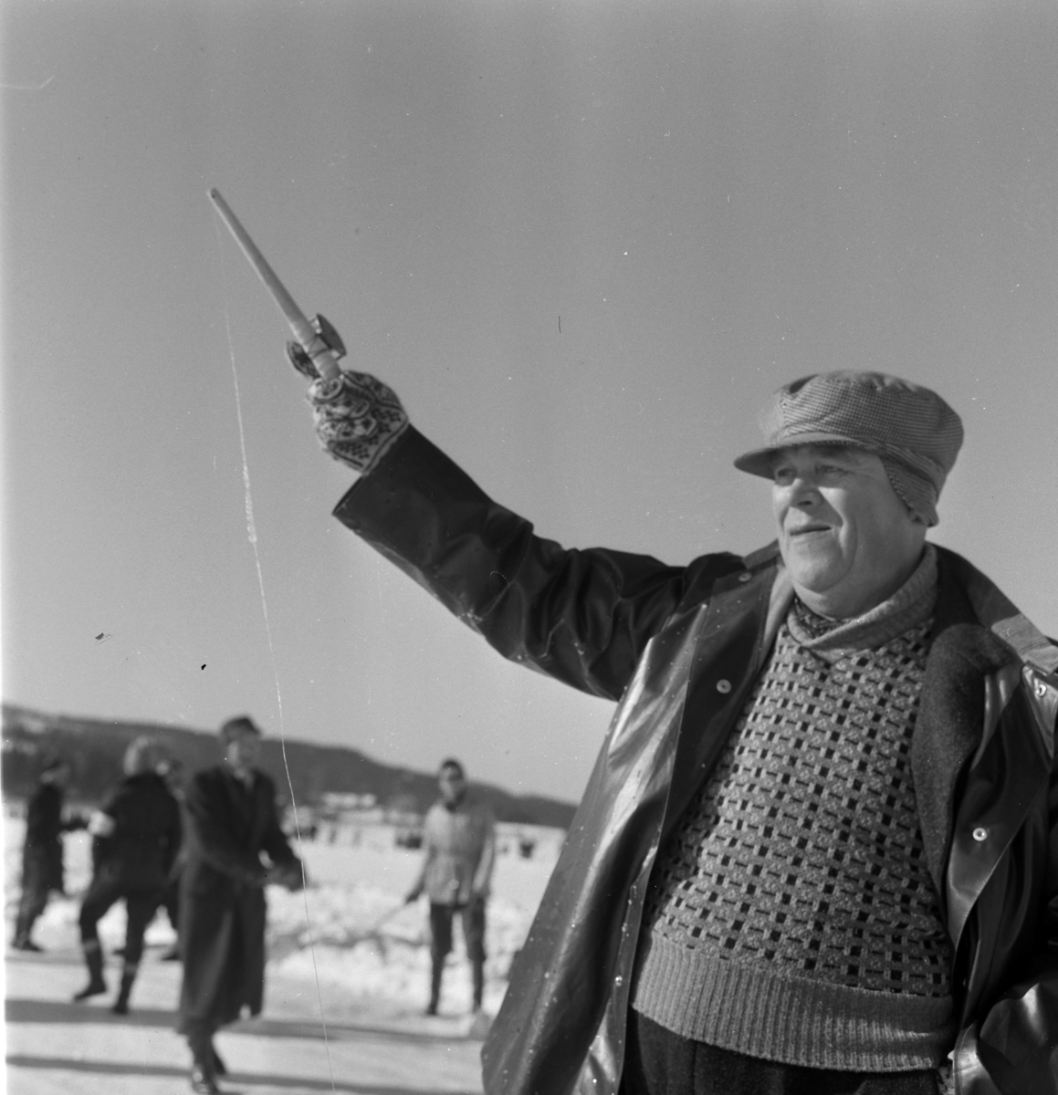 Pilkekonkurranse utenfor Strandsaga i Brumunddal 09. 03. 1958. Fiskekonkurranse på Mjøsisen. Isfiske. ukjent pilker. 
Premier i pilkekonkurransen var bla. en bil, Skoda 1958 modell, motorsykkel, kjøleskap, reiseradio. Se. Na-00293-31 og Na-00293-32 for flere opplysninger. 