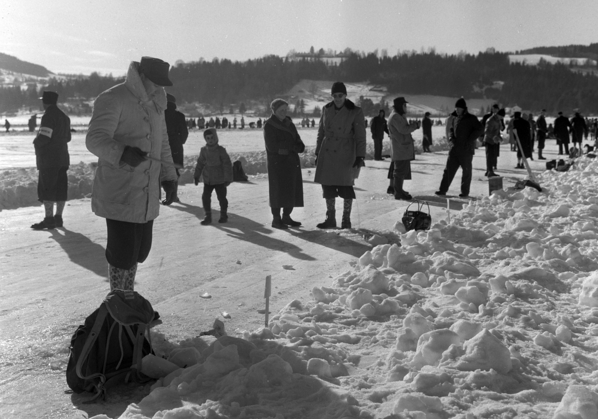 Pilkekonkurranse utenfor Strandsaga i Brumunddal 09. 03. 1958. Fiskekonkurranse på Mjøsisen. Isfiske. ukjent pilker. 
Premier i pilkekonkurransen var bla. en bil, Skoda 1958 modell, motorsykkel, kjøleskap, reiseradio. Se. Na-00293-31 og Na-00293-32 for flere opplysninger. 