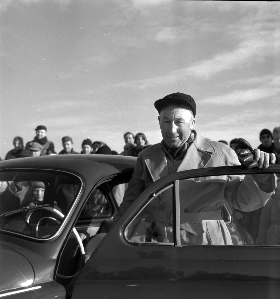 Pilkekonkurranse utenfor Strandsaga i Brumunddal 09. 03. 1958. 
Vinneren av pilkekonkurransen Nils Bjørnerud fra Furnes ved bilen som var 1. premie. Fiskekonkurranse på Mjøsisen. Isfiske. 
Premier i pilkekonkurransen var bla. en bil, Skoda 1958 modell, motorsykkel, kjøleskap, reiseradio. Se. Na-00293-31 og Na-00293-32 for flere opplysninger. 