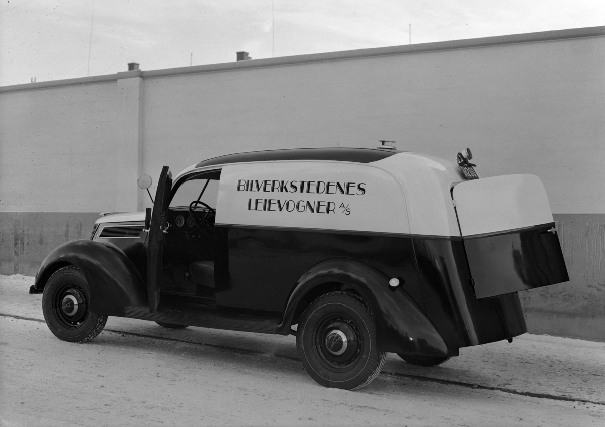 Hamar, Enggata 34, Oplandske Automobilforretning, etablert i 1923, bilforhandler av Ford i Hamar, Tidligere: Oplandske Automobilforretning & Reparationsverksted, varebil. Bilverkstedenes Leievogn no. 4. en Ford V8 1937 modell med norskbygd karosseri, Registeringsnummer D-1200 er et prøveskilt (den røde bunnfarven fremtrer som sort på foto).