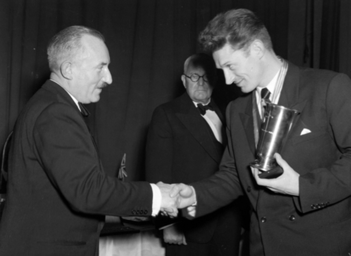 Hamar stadion, verdensmesterskap allround på skøyter 1952, VM 1952, fra festmiddagen i Festiviteten, verdensmester Hjalmar Hjallis Andersen fikk Brødrene Frangs store sølvfat, en aksje i Trondheims Skøyteklubs store vandrepokal, Peter Sinneruds skøytetrofe, overrekkes av Mr. Matthews, 
Verdensmesterskapet ble fyttet fra Trondheim til Hamar.