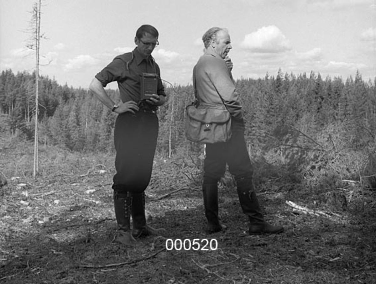 Fra befaring med viltstellkonsulent Arne Gabrielsen (til høyre på bildet).  Temaet for befaringa var muligens elgbeiteskader i skog, som var et tiltakende problem tidlig i 1970-åra, da dette fotografiet ble tatt. 