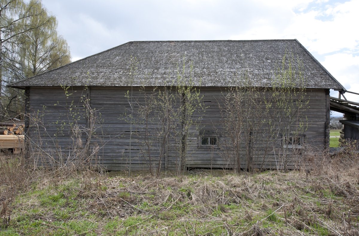 Låve med to fløyer i vinkel, laftet: Bygningen har saltak tekket med flis. Kjøringa går gjennom hele bygningen og har sin begynnelse over stallen i nord. Dette er et tidlig eksempel på en enhetslåve der mange funksjoner er samlet under et tak. Stallen har innredning for fem hester med krybbe og foringsgang. På langsiden inn mot tunet er det oppført et hus for hestevandring. Det har pyramideformet tak som hviler på stolper.