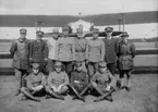 Grupporträtt. Stridsflygskolan på Malmen år 1927. Tolv män uppställda framför ett flygplan.