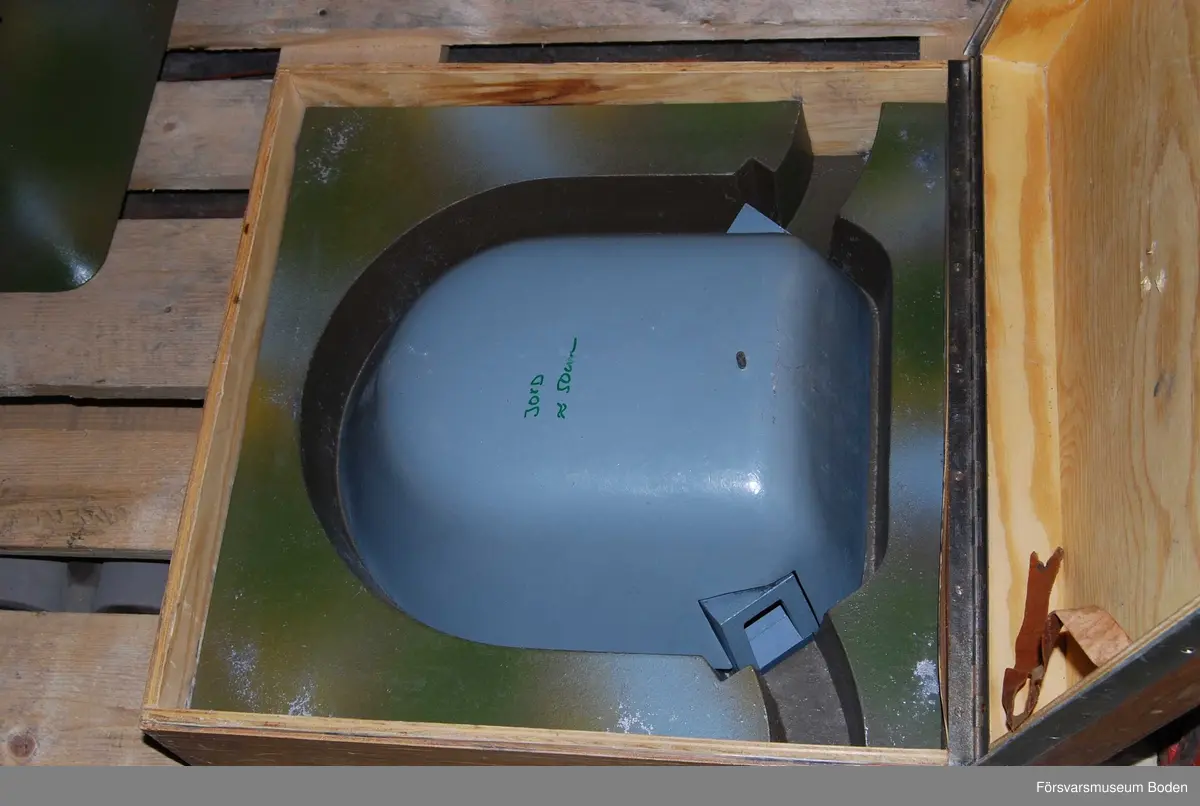 Modell i skala 1/25 av kupol, uppbyggd i flera avlyftbara lager av gjuten aluminiumlegering som målats. Placerad i trälåda med bärhandtag (defekt) och med gummifötter för att kunna ställas på högkant. Lagrens typ skrivna med tusch, vilket verkar ha gjorts i efterhand.