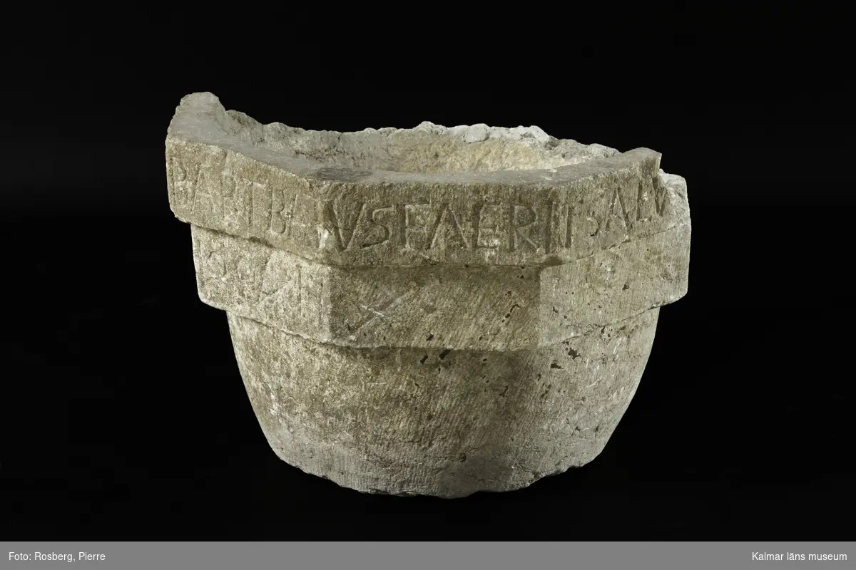 KLM 35218:1:1-4. Dopfunt, av kalksten, består av 4 delar. :1:1. Dopfuntscuppa, mått: mynning yttre diameter 65 cm, inner diameter 50 cm, skåldjup 18 cm, botten diameter 40 cm. Cuppan utförd i tre nivåer, de två övre delarna är åttakantiga och underdelen cylindrisk med svag konisk-konvex profil. Den övre åttakantiga nivån med latinsk inskription, text med versaler, inskrift: ...ERIT ET BABTATUS FUERIT SALV... Den undre åttakantiga nivån har texten ...RIT CONDEMNABITUR. (Inskriften är ej helt komplett, del av citat från, Marcus 16:16. Hela citatets översättning, Bibeln 2000: Den som tror och blir döpt skall räddas, men den som inte tror skall bli dömd.)  Den undre nivån har kryssristad dekor. Underdelen är odekorerad. Grund skål. Cuppans överkant, är till hälften bortslagen, tre av bitarna finns kvar. Utan uttömningshål. :1:2-4 tre lösa delar tillhörande övre kanten av cuppan. Alla tre delar har otydlig latinsk inskription, text med versaler och tecken.