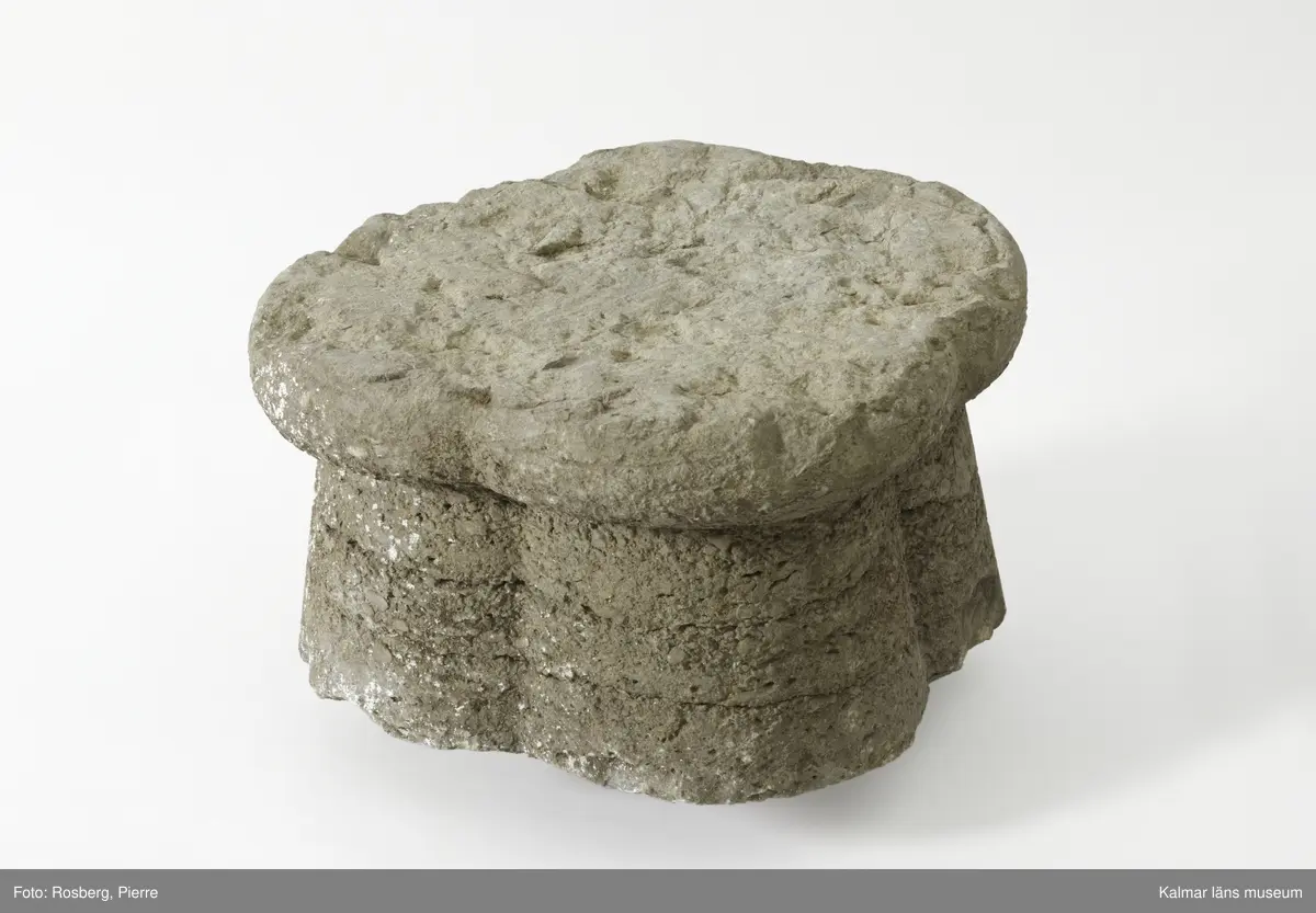 KLM 35218:2:1-2. Dopfuntsfot, av kalksten, 2 delar. Mått, hela foten: höjd 40 cm, största bredd 43 cm. Foten sammansatt av fyra halvkolonner, konade med fyrklöverformad vulst upptill. Saknar fotplatta. Foten som är det enda som återstår av funten är eroderad efter lång tid utomhus. Den har en liten skada vid skarven och en horisontell spricka.