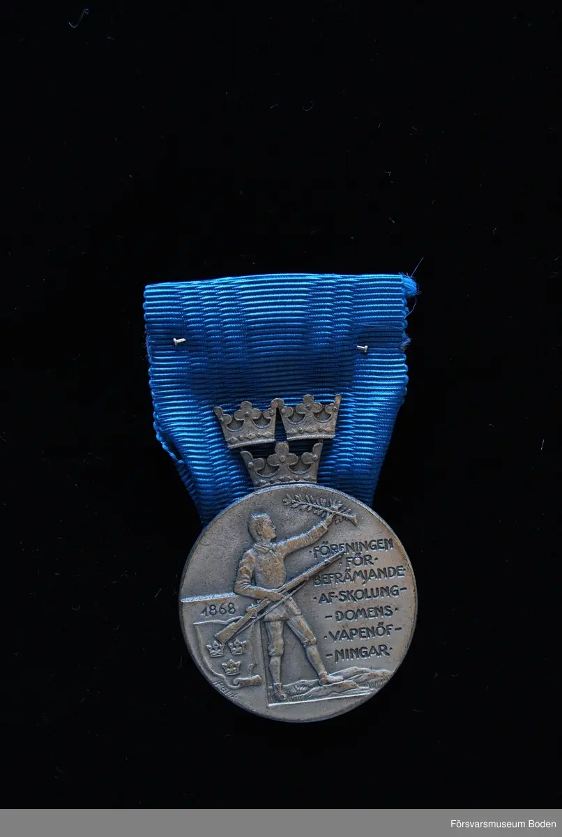 Tavla med uppsatta medaljer på svart sammet. Har tillhört Karl Hjalmar Lindskog, finlandsfrivillig 1939-1940. Från vänster på bilden:
1. Vinterkrigets minnesmedalj med svärd och spänne, Lappi, järn. Urkund finns i pärm under FMB.002361.
2. Frihetsmedaljen 2.klass, brons, urkund finns i pärm under FMB.002361.
3. Medalj från Föreningen för skolungdomens vapenövningar, silver.
4. Svärdstecken.
Överst på tavlan ett släpspänne för dessa medaljer.