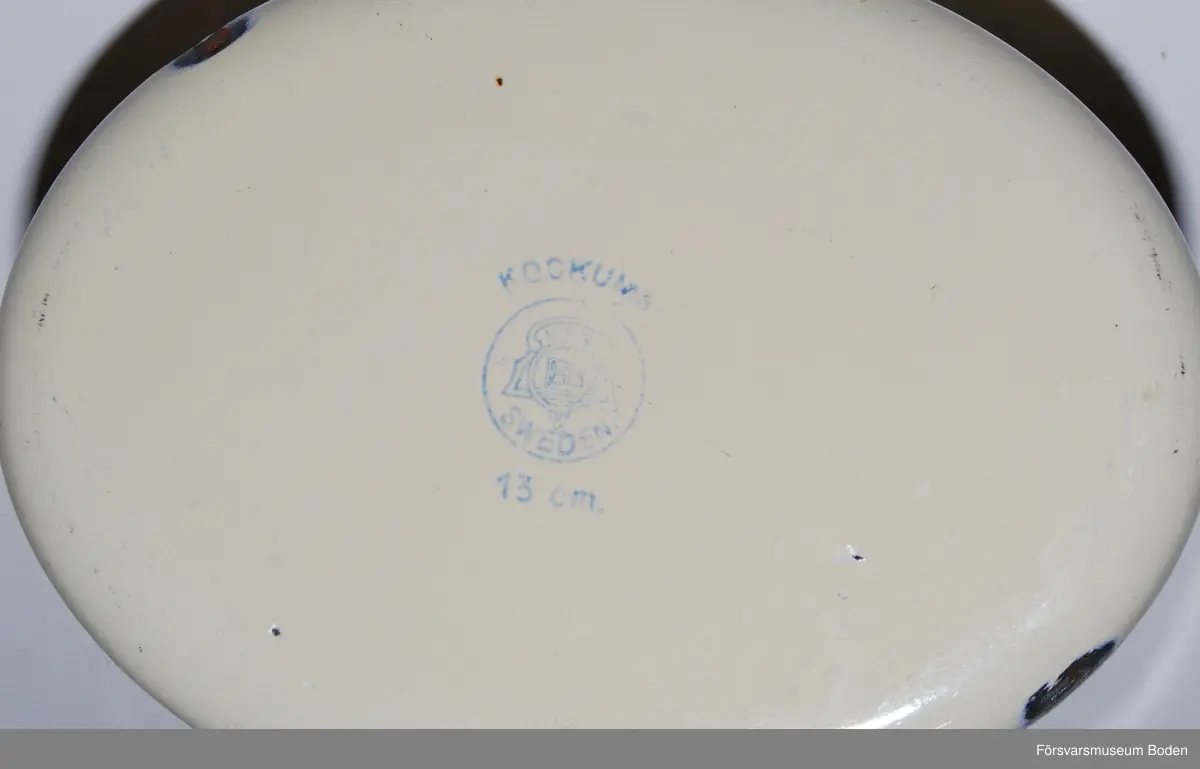 Gul med grön kant, tillverkad efter 1935 då dessa färger började användas. Bredd 13 cm.