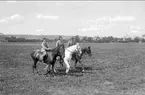 Kan vara Ingrid och Peter samt sonen Peter född 1926. Ryttaren i mitten förefaller vara minst 15 år. Bilden är i så fall tagen mellan 1941-47 i Skövde. Uppgiftslämnaren ryttm. Cleas Lewenhaupt, Claesborg. Kortet är taget på fältet söder K 3 kasern.