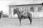 Livhusar i uniform m/1895 med tilldelad stamhäst utanför ridhuset.