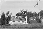 Skövde fältrittklubbs vårtävlingar 1938. Prishoppning på prishoppningsbanan öster kasern. I bakgrunden Dunkehallsåsen - en utmärkt plats för åskådare.