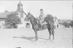 Livhusar i uniform m/1910 och mössa m/1895 på tilldelad stamhäst på K 3 kaserngård söder om skvadronstallet