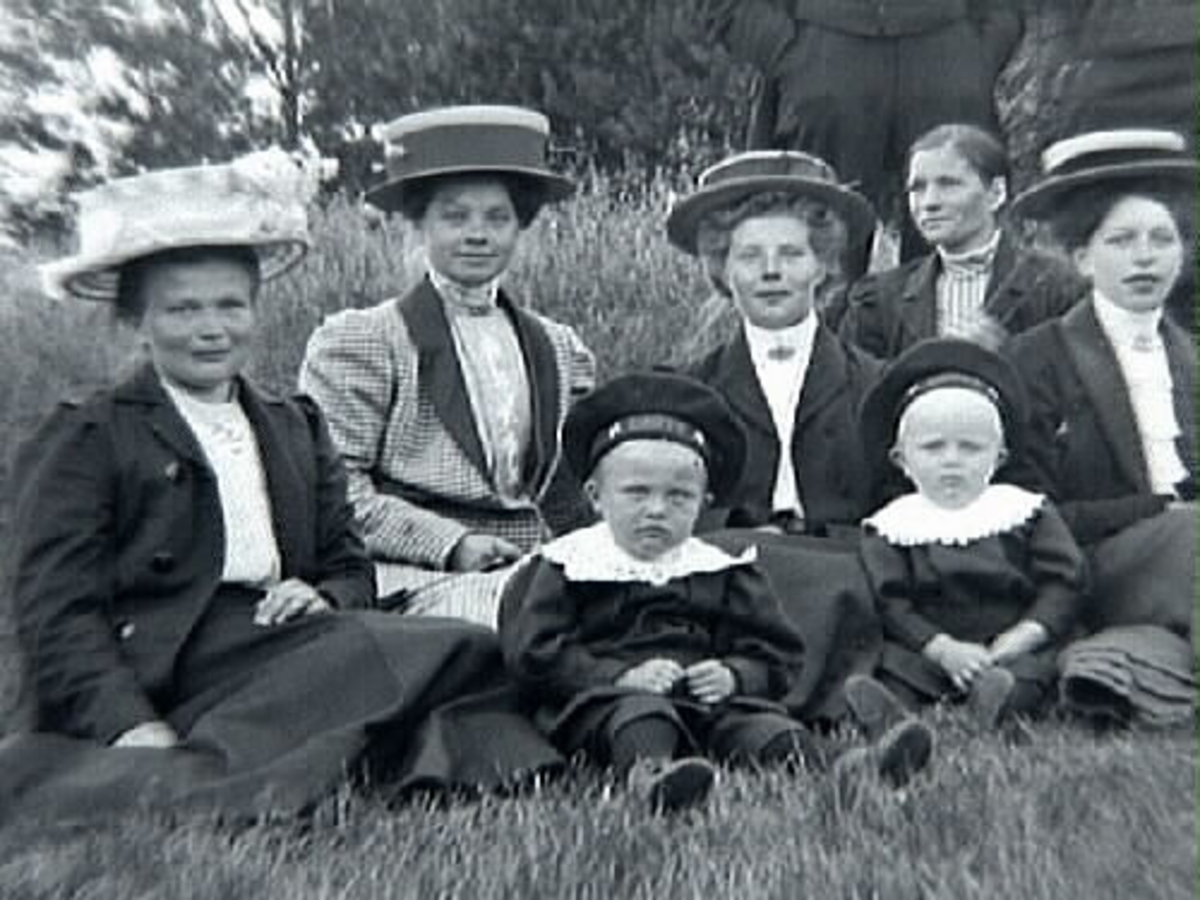 Gruppbild med c:a tjugo personer fotograferade utomhus. Mannen med plommonstop, stående trea fr vänster är Klas Johansson i Stenshult, född 1888.