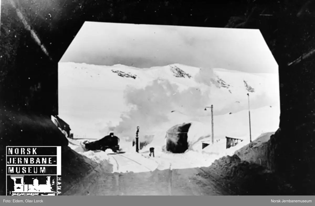 Vinterbilde fra Finse stasjon med østgående tog i spor 1, fotografert fra snøoverbygget i østenden